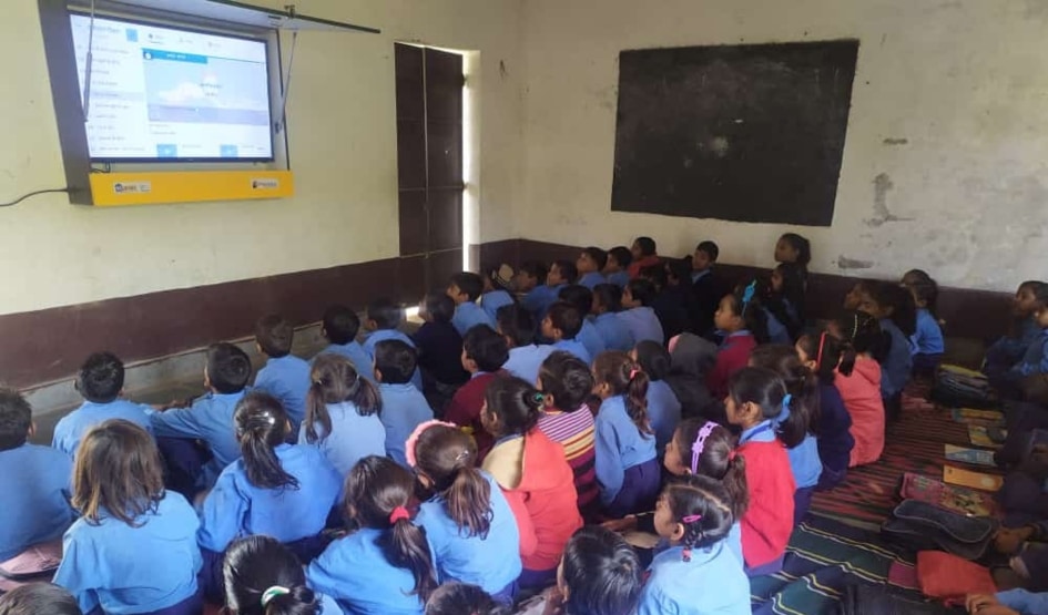 Children at a Shikshadwar non-formal education session watch a lesson together